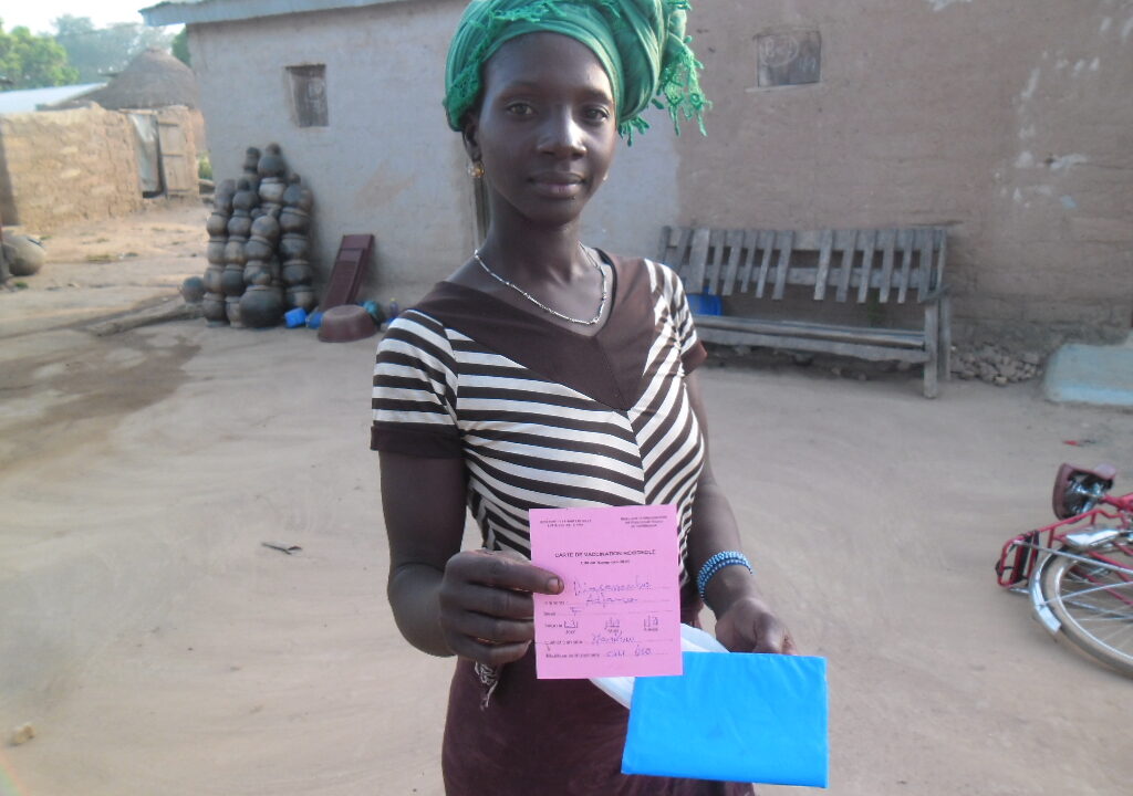 Mother holding her child measles vaccination card