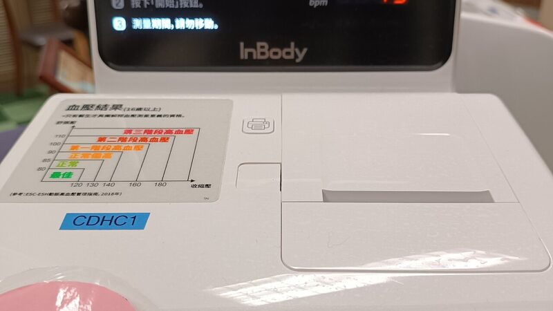 Electronic arm blood pressure monitor displaying readings
